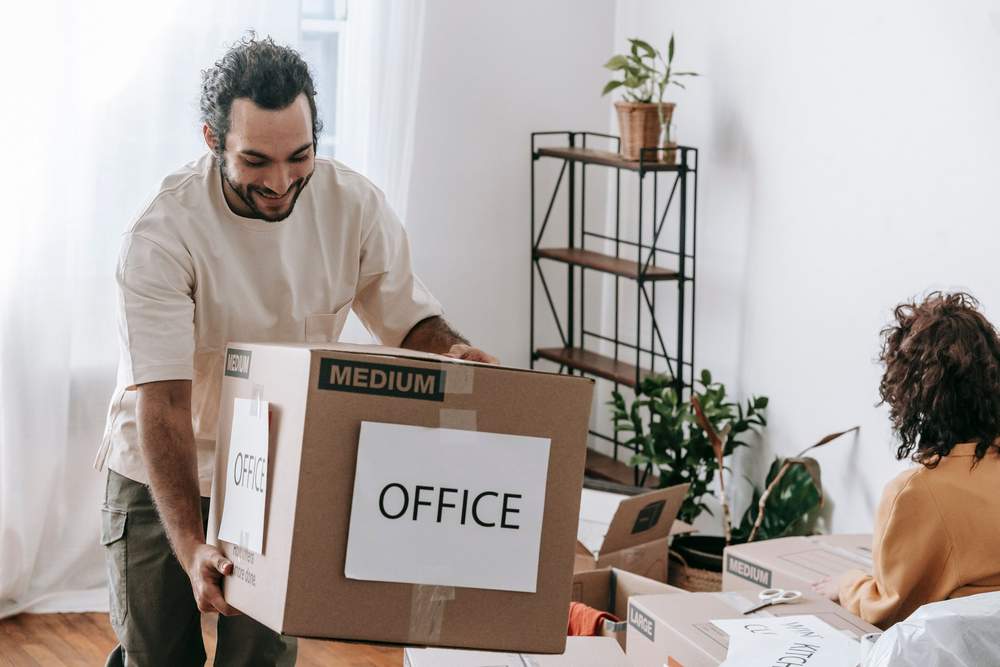 Two workers carrying a large furniture box during a property clear-out